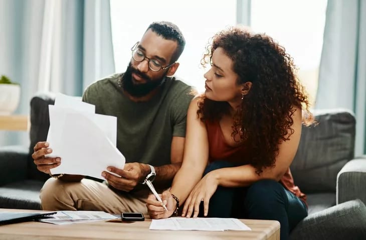 couple with bills signing papers.width .jpg