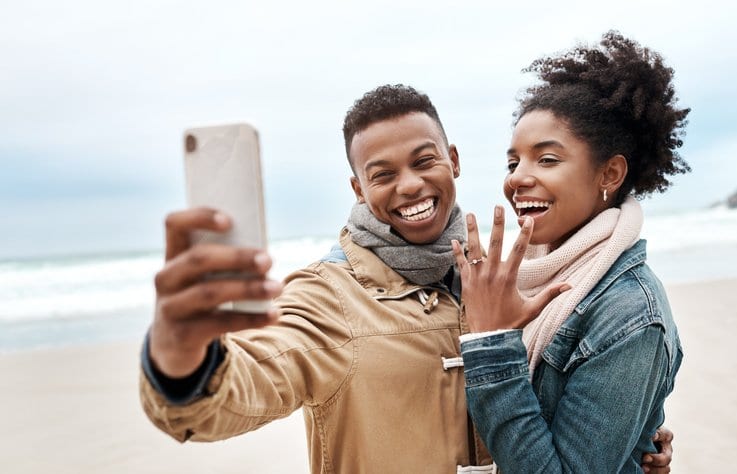 engaged couple on beach.width