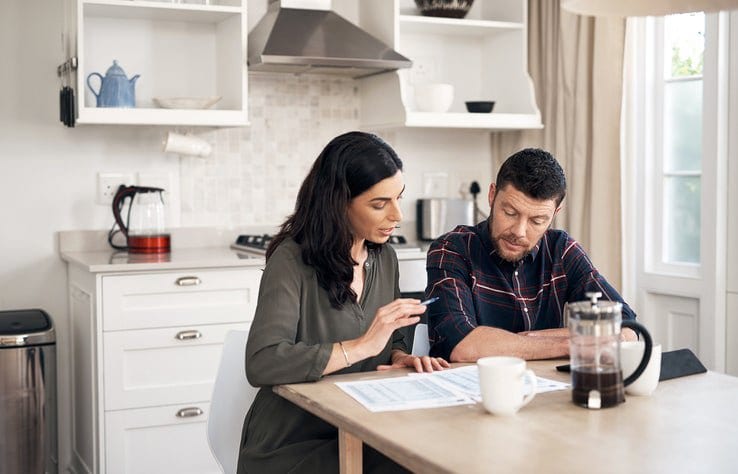 couple talking over papers in kitchen KRXubp.width