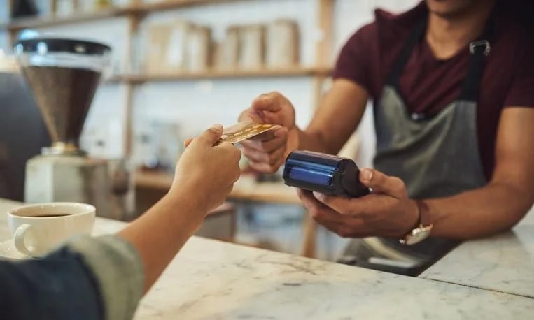 handing credit card to cafe cashier GWlfsUA.width .jpg