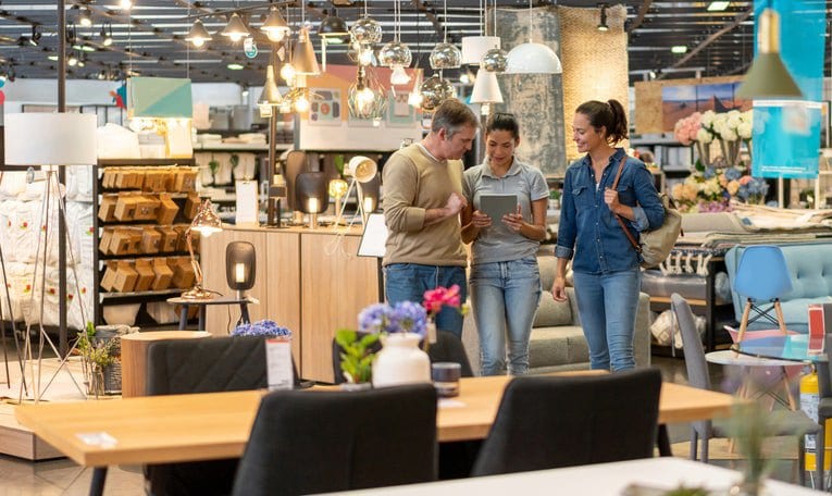 couple with saleswoman in furniture store Ztc.width .jpg