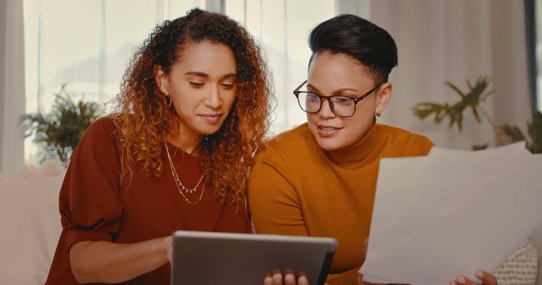 two people looking at tablet and paperwork aL.width .jpg
