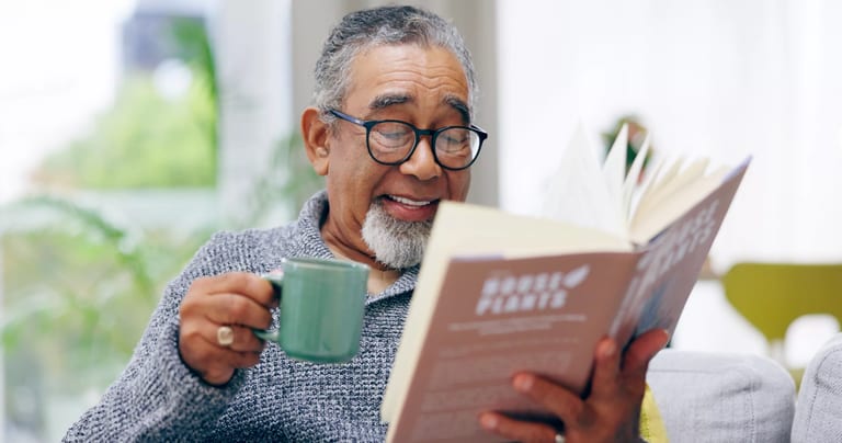 getty smiling happy reading book with mug.jpg