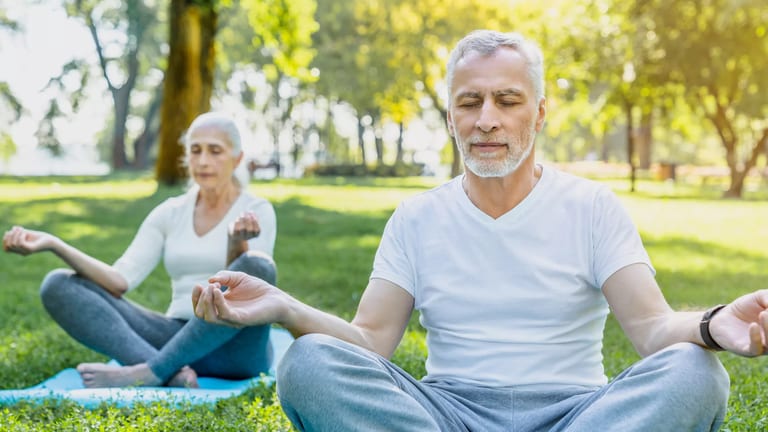 getty two people doing yoga or meditating outside health exercise.jpg
