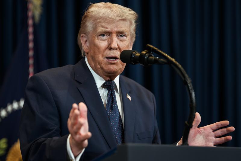 Donald Trump is delivering a speech from behind the presidential podium.