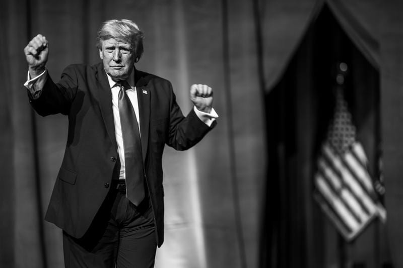 Donald Trump is doing his signature dance on stage in front of a crowd.