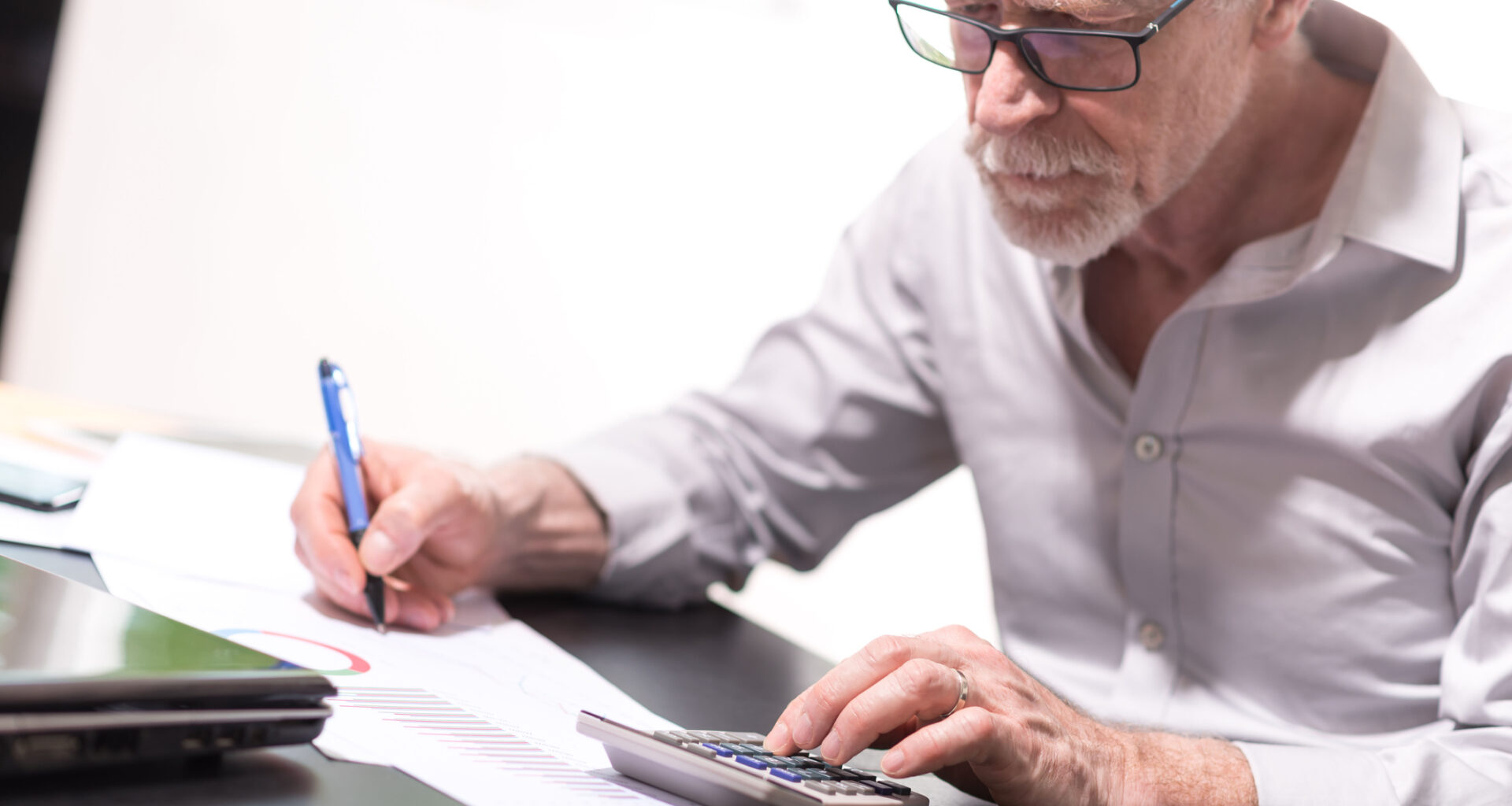 senior taking notes while using calculator gettyimages