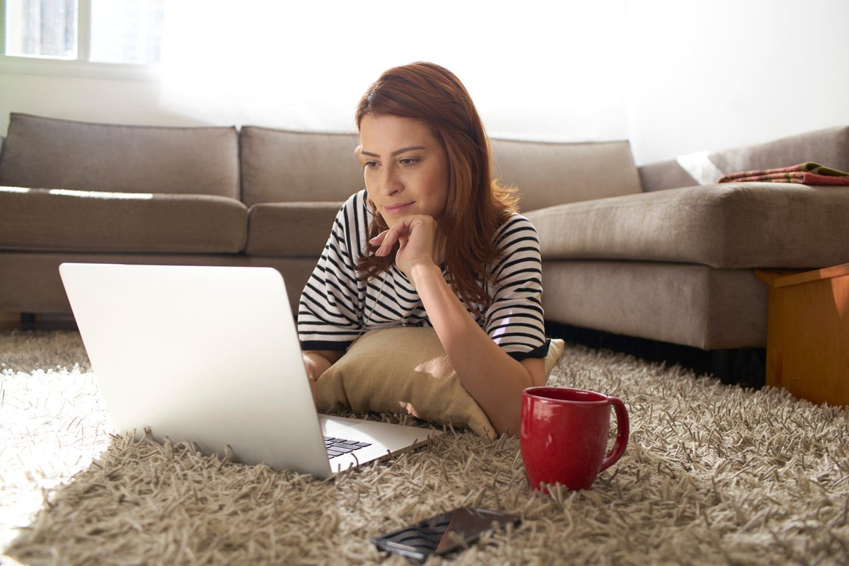 Woman using her laptop on her living room flo.width CvTcp