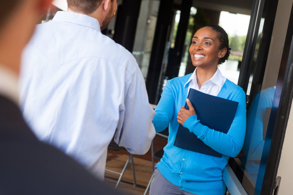 Woman shaking hands with others in an office .width AQtr.jpg