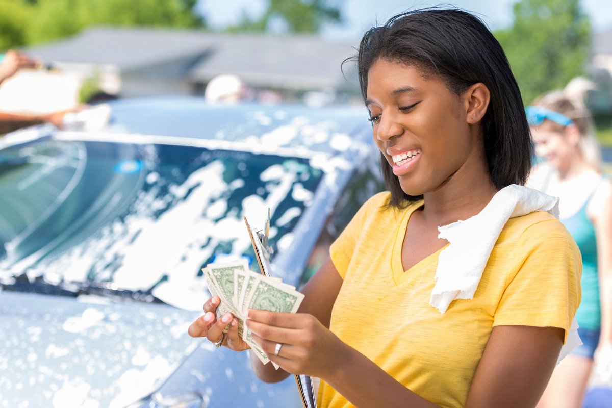 Young adult woman counts cash at car wash jbm.width .jpg