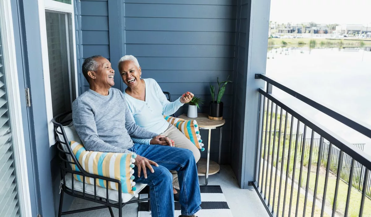 Happy mature couple sitting on balcony overlo.width gFthua.jpg