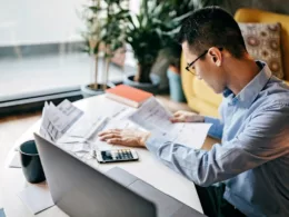 MAn using a calculator and looking over docum.width bFwUjX.jpg